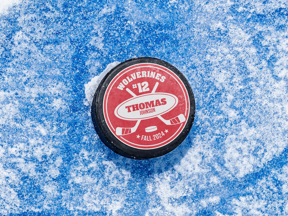 hockey puck with a red player and team name design with a hockey stick design with the words
Wolverines, 12, Thomas Johnson, Fall 2024