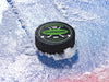 Hockey puck on ice rink with a green player and team name design with a hockey stick design with the words
Wolverines, 12, Stephano, Fall 2024