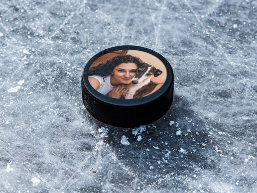 single custom photo hockey puck with woman and dog photo sitting on top of ice