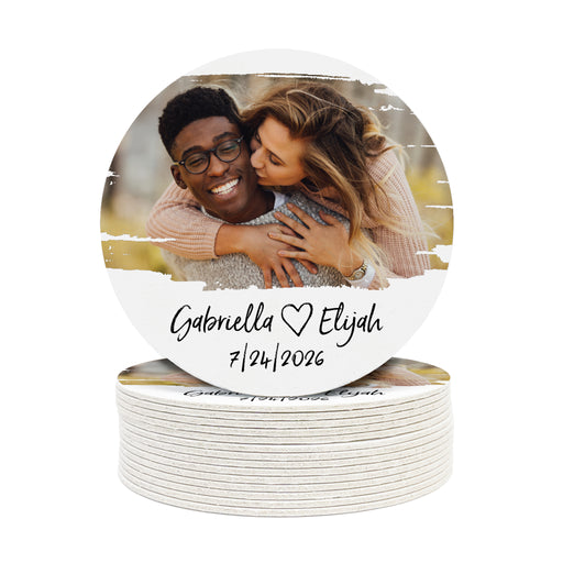 A stack of white round coasters with a picture of a couple and custom text on it.