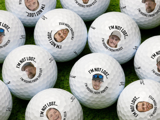 Multiple Titleist golf balls shown with I'm not lost, I'm hiding from design with different names and faces on each ball.