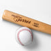 wooden mini baseball bat with custom laser engraved design that features a coach name design with team and year says "Coach Torres, Giants 2023" on a white surface next to a baseball