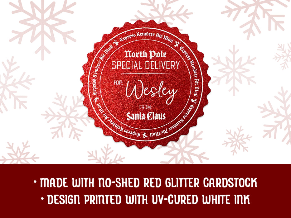 A red glitter cardstock Santa gift tag is shown on a white background with red snowflakes. Text underneath the tag reads: Made with no-shed red glitter cardstock, Design printed with UV-cured white ink.