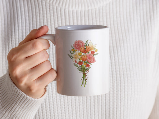 woman in white sweater holding a 15 ounce ceramic mug featuring artwork of a bouquet of pastel spring flowers