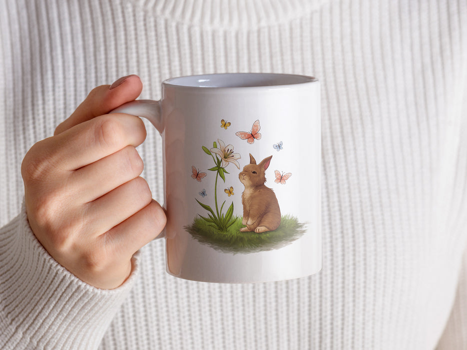 a woman holding a coffee mug with a rabbit on it