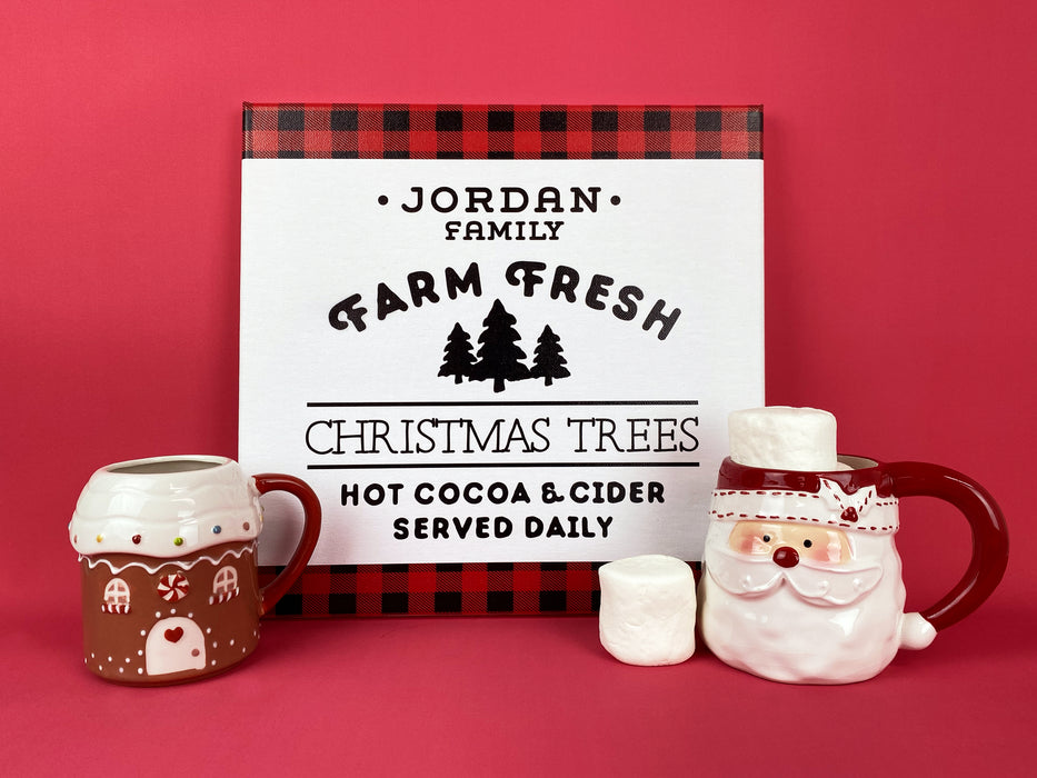 Canvas is shown with two Christmas mugs and marshmallows. Farm Fresh Christmas Trees design shown on canvas. Design has red and black plaid border with black text, Jordan Family Farm Fresh Christmas Trees Hot Cocoa & Cider Served Daily.