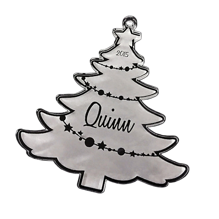 Acrylic ornament is shown on white background. Ornament design is a Christmas tree with a name and the year.