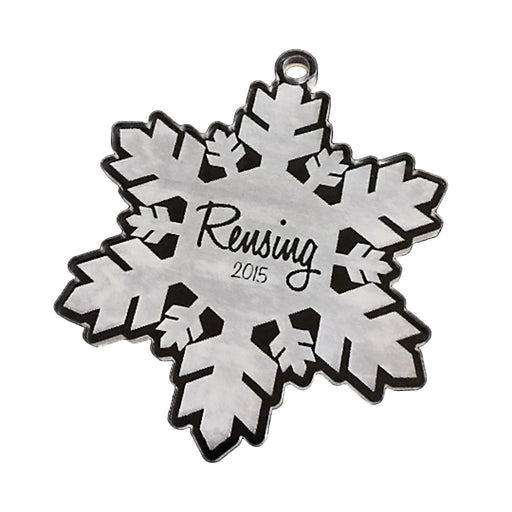 Acrylic ornament is shown on white background. Ornament design is a snowflake with a last name and the year.