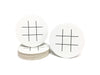 Single coaster is shown on top of a stack of coasters with another coaster sitting next to it on a white background. Coasters feature Tic Tac Toe design. This design has a tic tac toe game printed in black on white coasters.