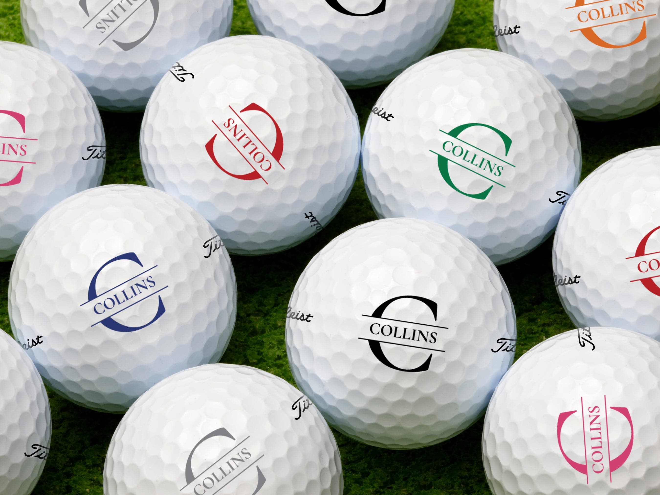 single white titleist golf ball with custom personalized black initial printed design on white golf tee against golf course grass background