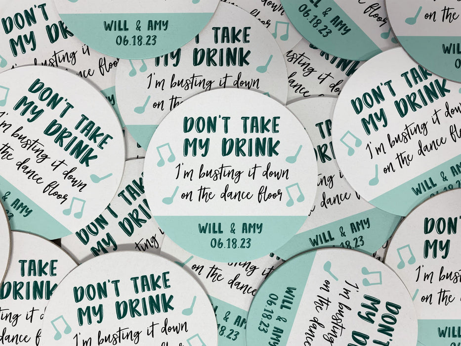 Multiple coasters spread in all different directions. Coasters say Don't take my drink, I'm busting it down on the dance floor. Married couple names are below with wedding date.