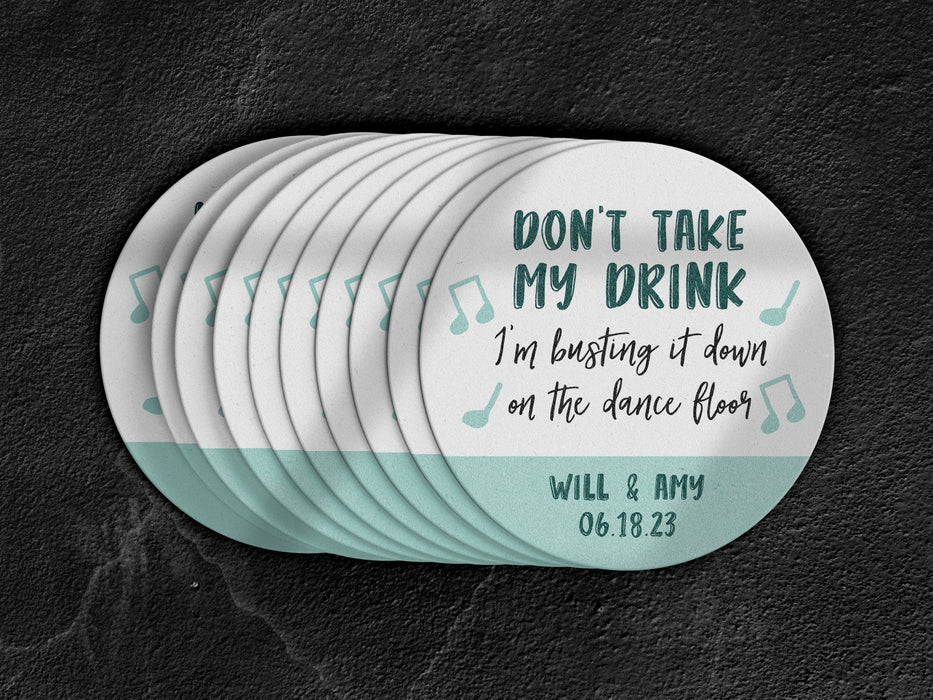 Stack of coasters spread out on black marble background. Coasters say Don't take my drink, I'm busting it down on the dance floor. Married couple names are below with wedding date.