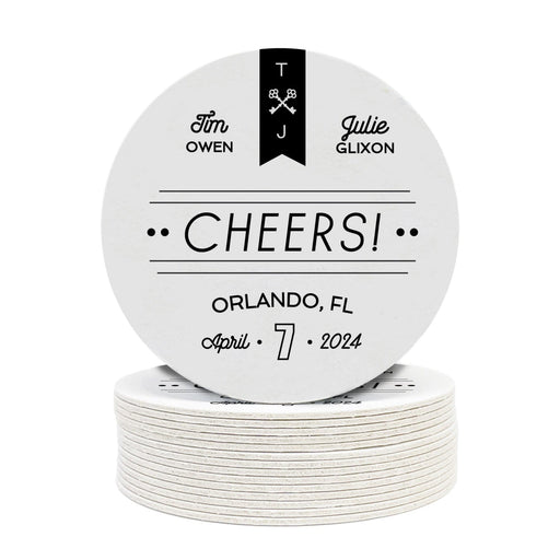 Stack of coasters with single coaster on top on a white background. Coasters feature CHEERS! Modern Wedding design. Coasters show married couple names and first name initials, the word “CHEERS!”, and the wedding location and date. Design is printed in black on a white coaster. These coasters also have decorative keys, lines, and dots on it.