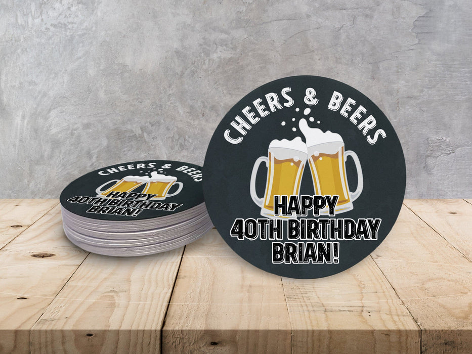 A stack of coasters by a single coaster on wooden table. Coasters say Cheers & Beers, Happy 40th Birthday Brian!
