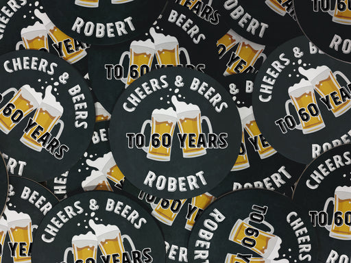 Multiple coasters spread in all different directions. Coasters say Cheers & Beers to 60 Years Robert!