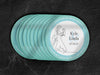 Stack of coasters spread out on black marble background. Coasters say Please Don't Take My Drink, I'm Dancing in white around a teal border. Coasters show an illustration of a married couple dancing beside their names and wedding date.