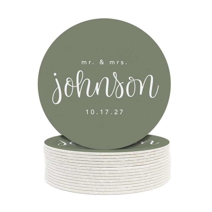 A stack of round coasters with the words mr and mrs Johnson on them against a white background. Coasters feature a custom last name design with a married couple's last name and wedding date.