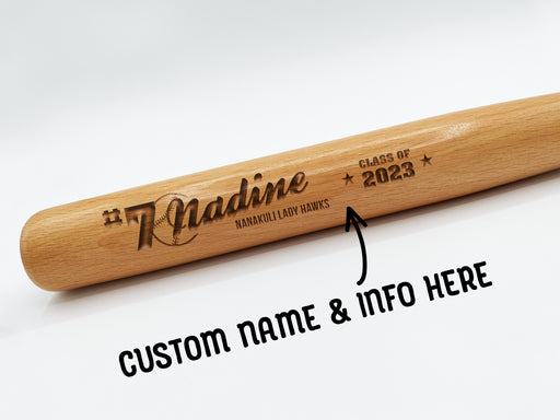 wooden mini baseball bat with custom laser engraved design that features a name with a baseball with a number and says "#7 Nadine, Nanakuli Lady Hawks, class of 2023" on a white surface with arrow and text that says custom name & info here