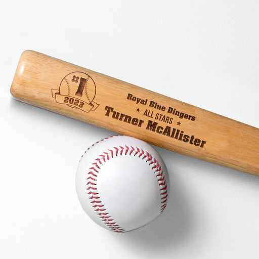 wooden mini baseball bat with custom laser engraved design that features a baseball team design with a team name and says "#1 2023, Royal Blue Dingers, All Stars, Turner McAllister" on a white surface next to a baseball