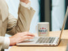 businessman sitting at desk with computer with a white mug with red white and blue American design with typography that says Bartlet for America with Red Stars