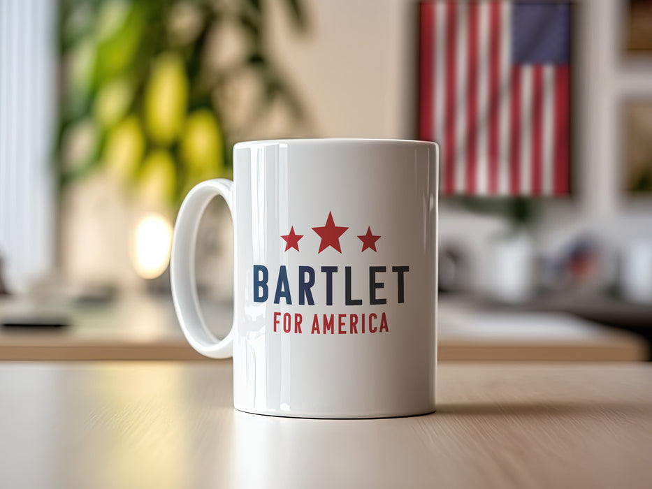 white mug with red white and blue American design with typography that says Bartlet for America with Red Stars on wooden table with house plants and an American flag in the background