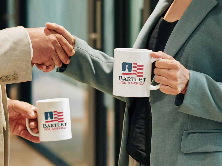 two business people shaking hands both holding white mugs with red white and blue patriotic American flag design with a king chess piece with Typography that says Bartlet for America