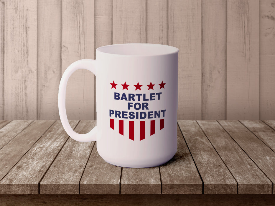 white mug with red white and blue American design with typography that says Bartlet for president with Stars and Stripes on wooden table with a wooden wall