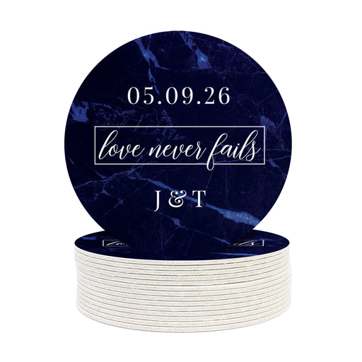 A stack of coasters with one on top is shown against a white background. Coasters feature Love Never Fails design. This design has a dark blue marble background and the happy couples first name initials and wedding date in white writing.