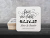 A stack of coasters by a single coaster on a black wooden table. Coasters say Save the Date, wedding date, married couple names, and formal invitation to follow.