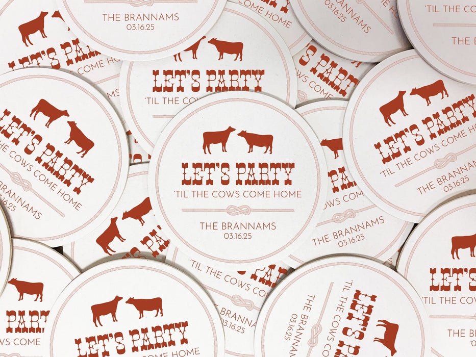 Coasters shown scattered on the surface of a table. Coasters feature Til The Cows Come Home design. Design shows two cows with the saying Lets Party Til The Cows Come Home with newlyweds last name and wedding date.