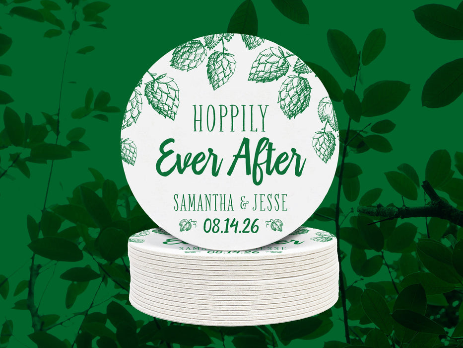 A stack of coasters is shown with a leafy background behind it. Coasters feature Hoppily Ever After design. This design uses green lettering and sketched drawings of beer hops. Wedding couples names and date can be customized.