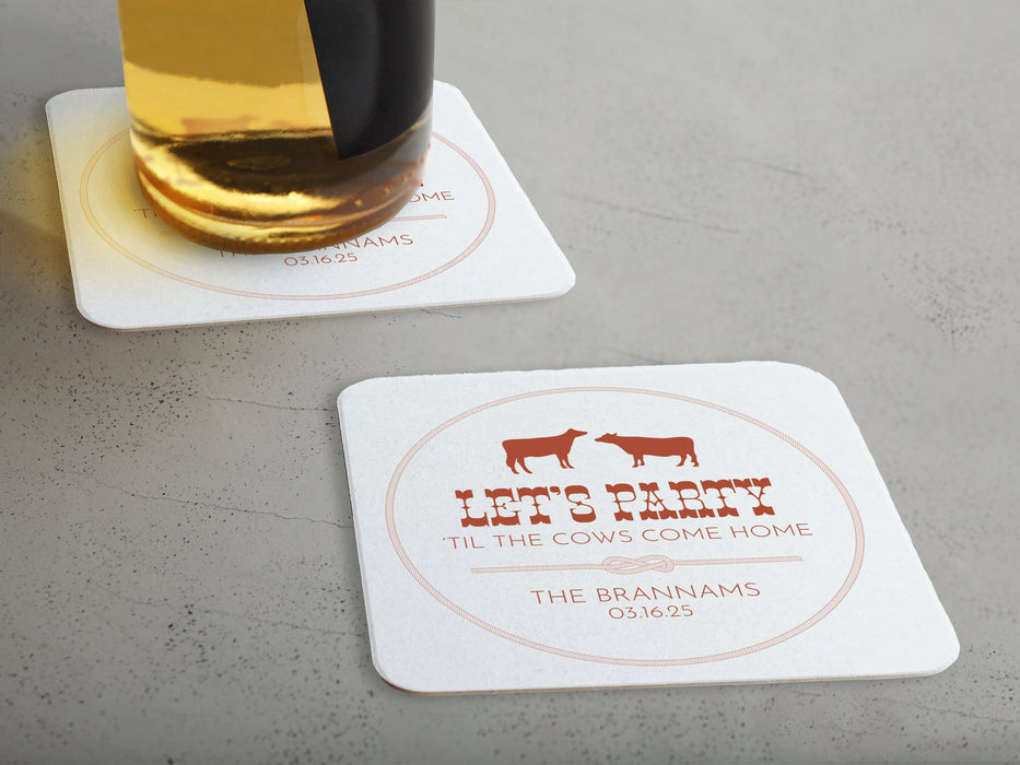 One coaster has a beer glass on it and an empty coaster sits beside it. Coasters feature Til The Cows Come Home design. Design shows two cows with the saying Lets Party Til The Cows Come Home with newlyweds last name and wedding date.