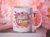 white mug in front of pink room surrounded by home decor such as books and flowers with a floral design that says Auntie Tianna
