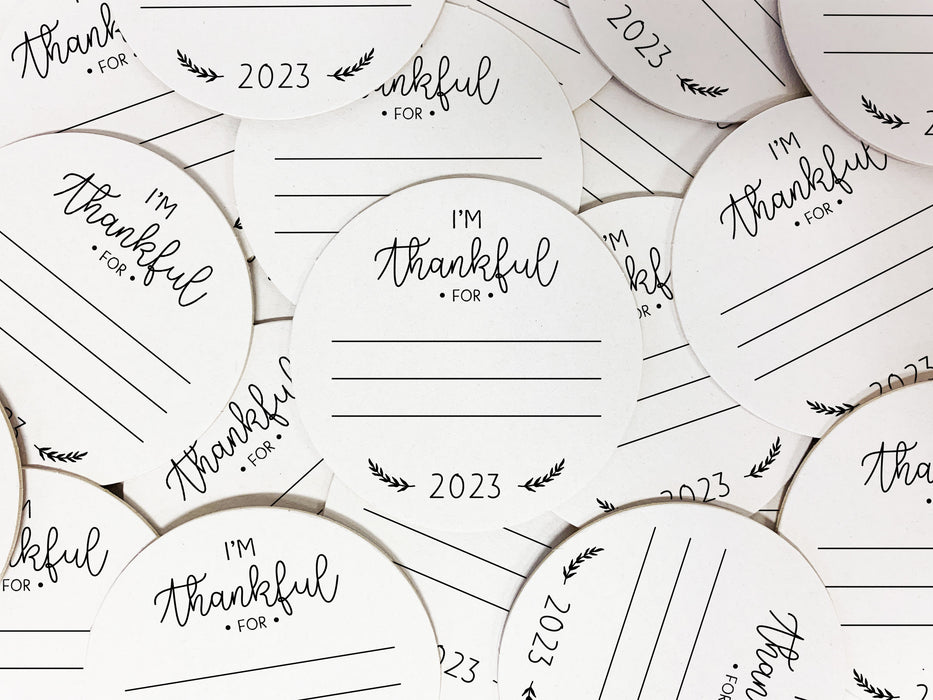 Multiple coasters spread in all different directions. Coasters shows the text I'm thankful for, has lines for writing in a response, and current year.