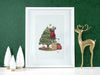 white frame with christmas print of mouse decorating tree against a green background ontop of a white counter surrounded by holiday decor such as white pine trees and a golden sparkly reindeer