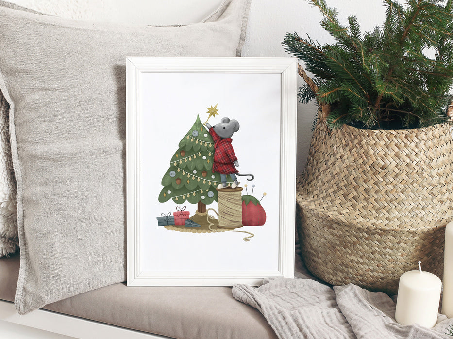 white frame on grey couch with a christmas print surrounded by grey pillows, candles, and a pine plant in a straw basket