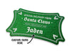 A green glitter cardstock Santa gift tag is shown on a white surface. The text below it reads, Custom Name Here.