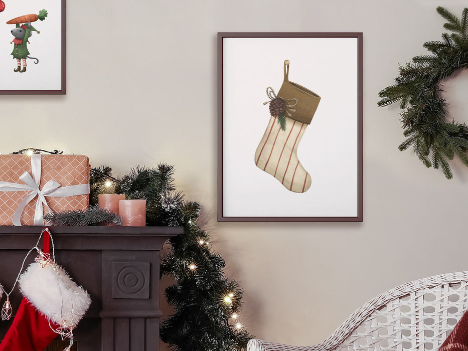 brown frame with christmas print of rustic stocking on white wall surrounded by holiday decor such as pine leaves, christmas lights, stocking, christmas gift, white chair and pillow, next to a brown fireplace