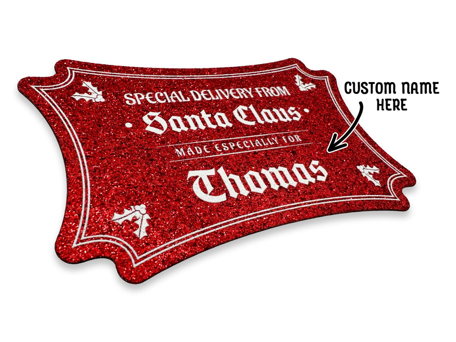 A red glitter cardstock Santa gift tag is shown on a white surface. The text beside it reads, Custom Name Here.