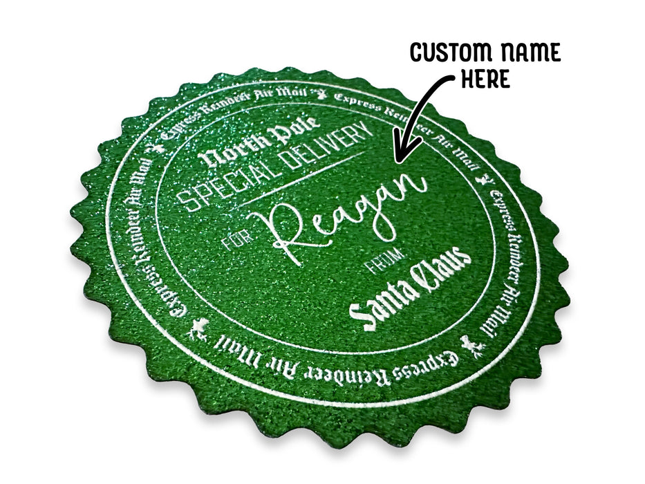 A green glitter cardstock Santa gift tag is shown on a white surface. The text above it reads, Custom Name Here.
