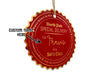 A gold foil cardstock hanging Santa gift tag is shown on a white surface. The text beside it reads, Custom Name Here.