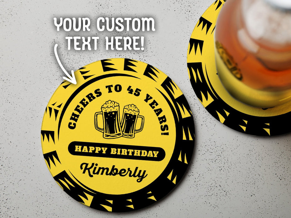 One coaster has a drink on it and an empty coaster sits beside it on a grey background. Text above coasters say your custom text here! Coasters say Cheers to 45 Years! Happy Birthday Kimberly.