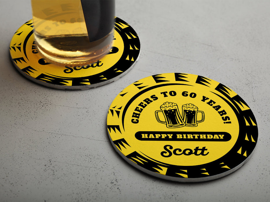 One coaster has a drink on it and an empty coaster sits beside it on a grey background. Coasters say Cheers to 60 Years! Happy Birthday Scott.