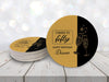 A stack of coasters by a single coaster sit on a white wooden table against a white glitter background. Coasters are designed in black and gold ink with cheersing champagne glasses. Coaster text reads Cheers to Fifty. Happy Birthday Diane.