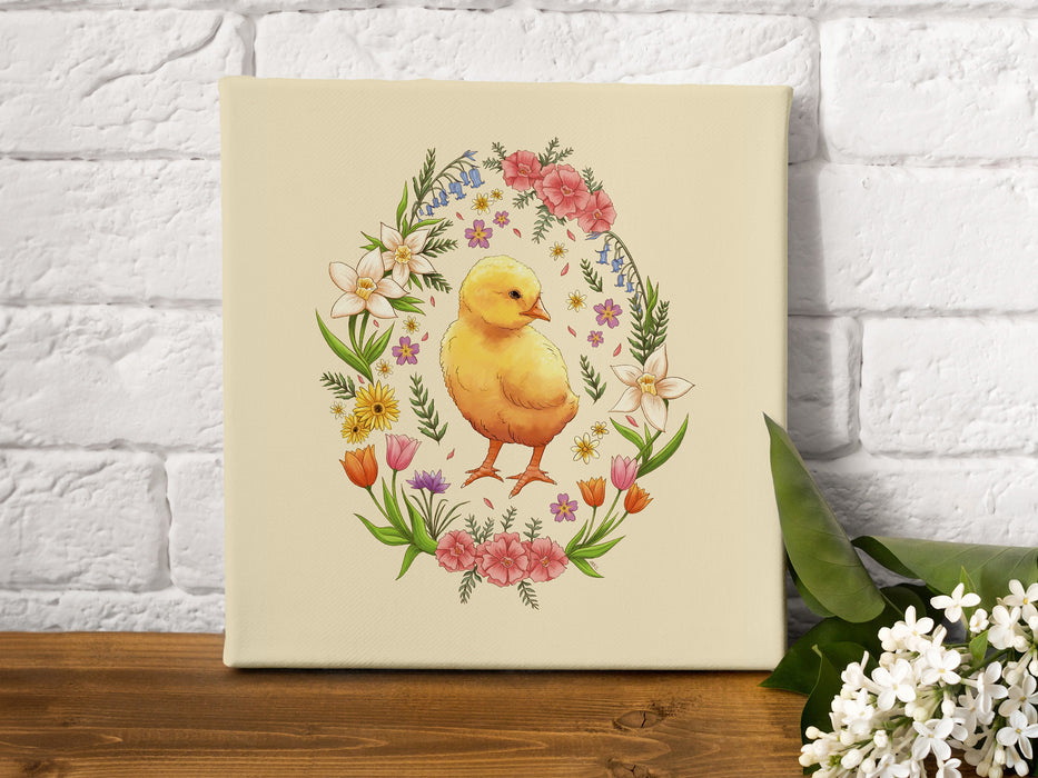 12x12 inch canvas with spring easter chick pastel easter art on wooden table next to some white flowers in front of a white brick wall