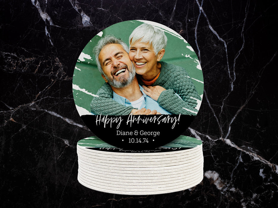 One coaster sitting on top of a stack of coasters with a black marble background. Coasters shown are customizable. Coasters are designed with custom photo, text, and brushed elements. Coaster text reads Happy Anniversary! Diane & George, 10.14.74