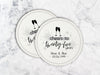 Two coasters sit on a marble surface. Coasters shown are customizable. Coasters are designed with gray sparkly elements, wine glasses, and the words Cheers to twenty-five years, custom names, and custom date.