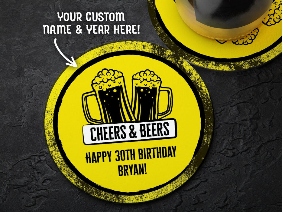 One coaster has a drink on it and an empty coaster sits beside it on a grey background. Text above coasters say your custom name and year here! Coasters say Cheers & Beers, Happy 30th Birthday Bryan!