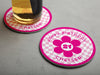 One empty coaster is shown with a beer glass on a second coaster. Coasters are designed with hot and light pink ink. Coaster text reads Happy Birthday Chelsea with the number 21 in the center of a pink flower.