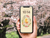 Phone Wallpaper Included with Download
Image of a hand holding a phone with easter phone wallpaper with cherry blossom trees in the background